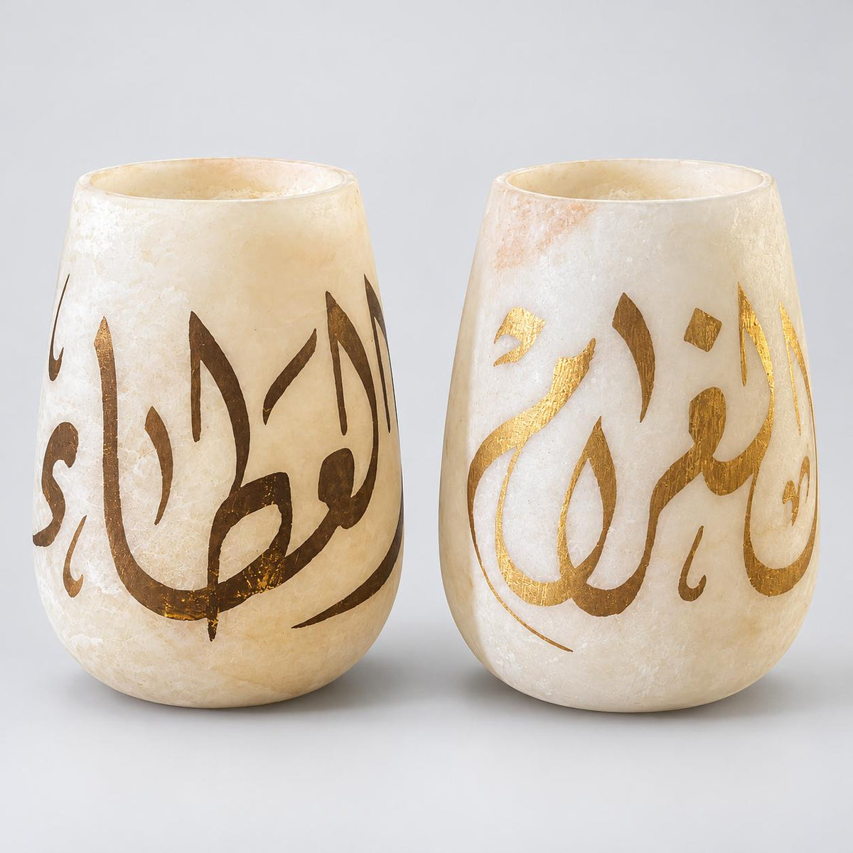 Elegant translucent alabaster vases adorned with Arabic calligraphy in gold leaf